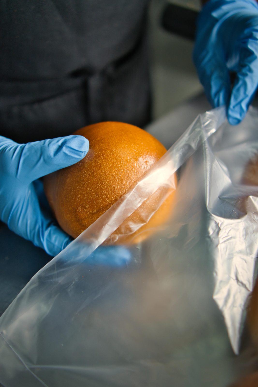 Colaborador empacando pan de hamburguesa en bolsas