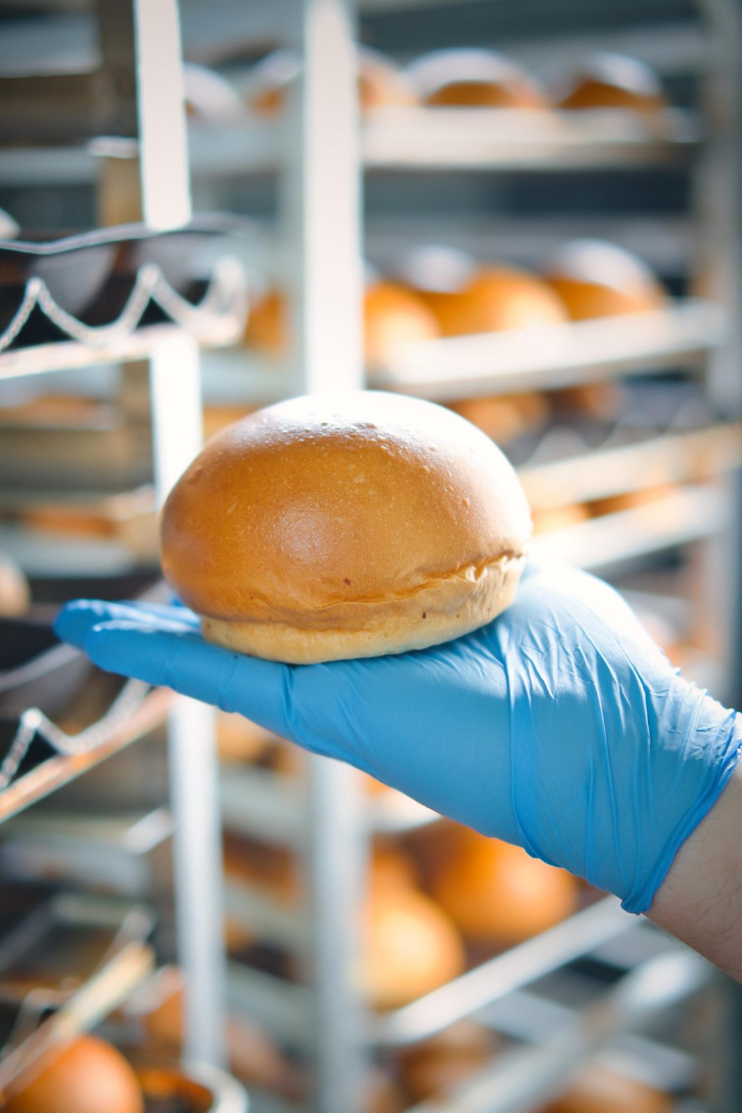 Colaborador mostrando un pan de hamburguesa terminado
